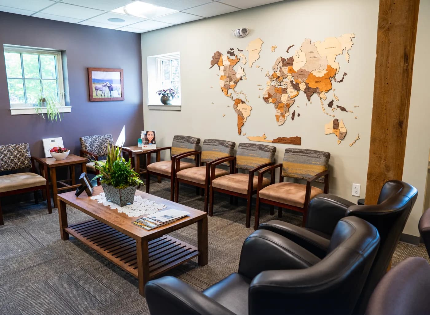 Atlas Dental office waiting area with modern seating, wooden accents, and a decorative world map wall.